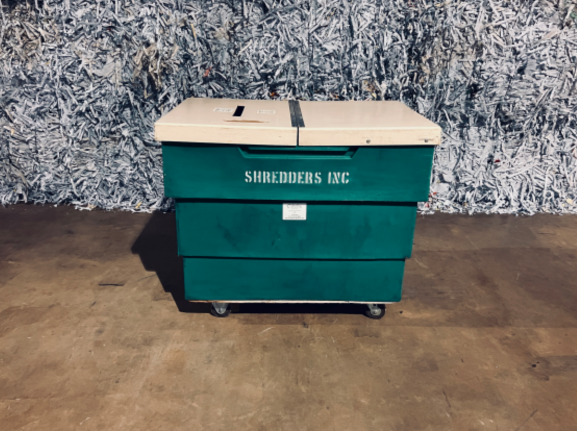 A green box with two white lids on wheels.